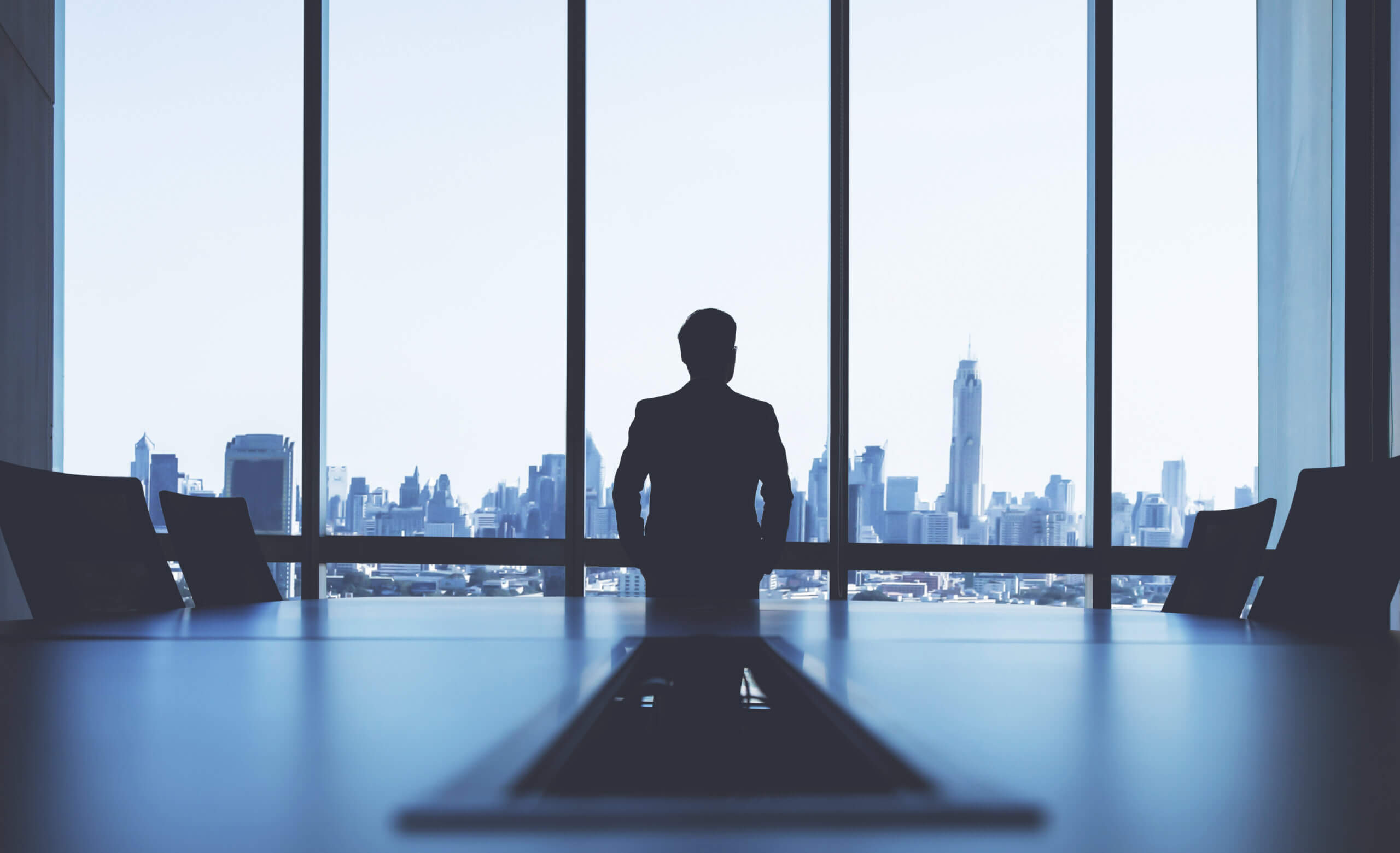man in boardroom staring out of window
