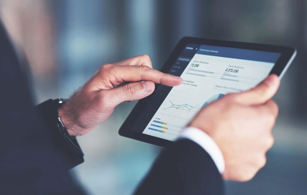 technology man holding iPad showing data scaled